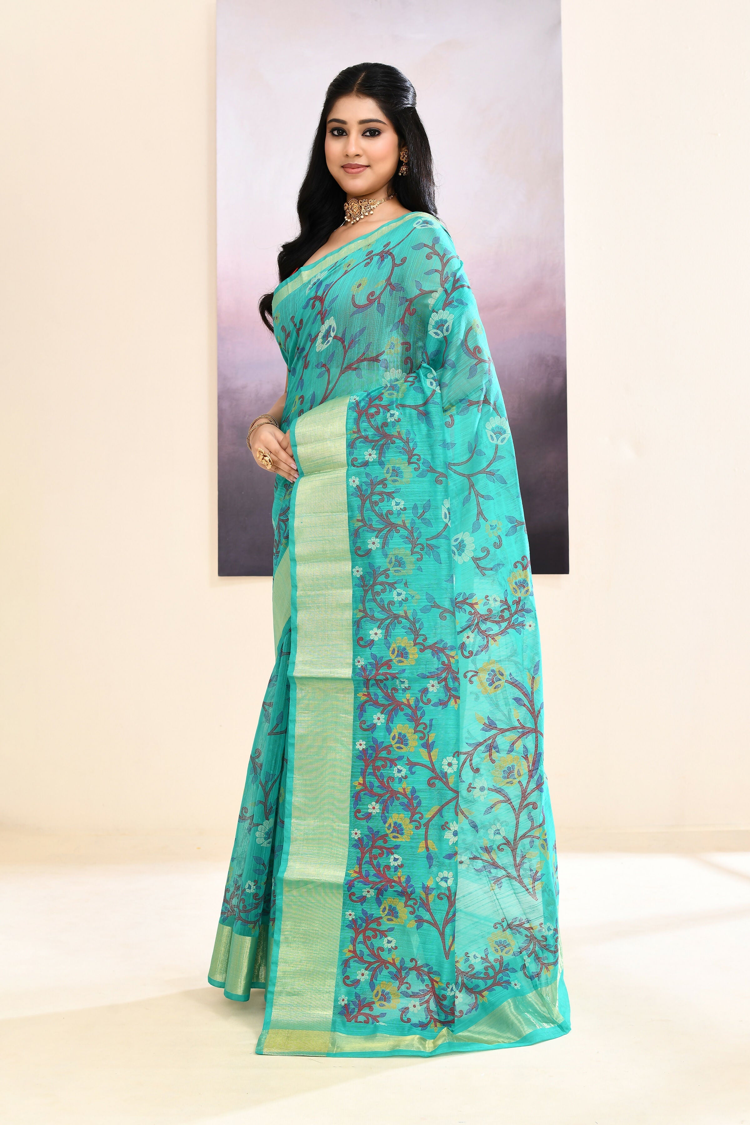 Turquoise embellished cotton blend printed saree with intricate detailing.