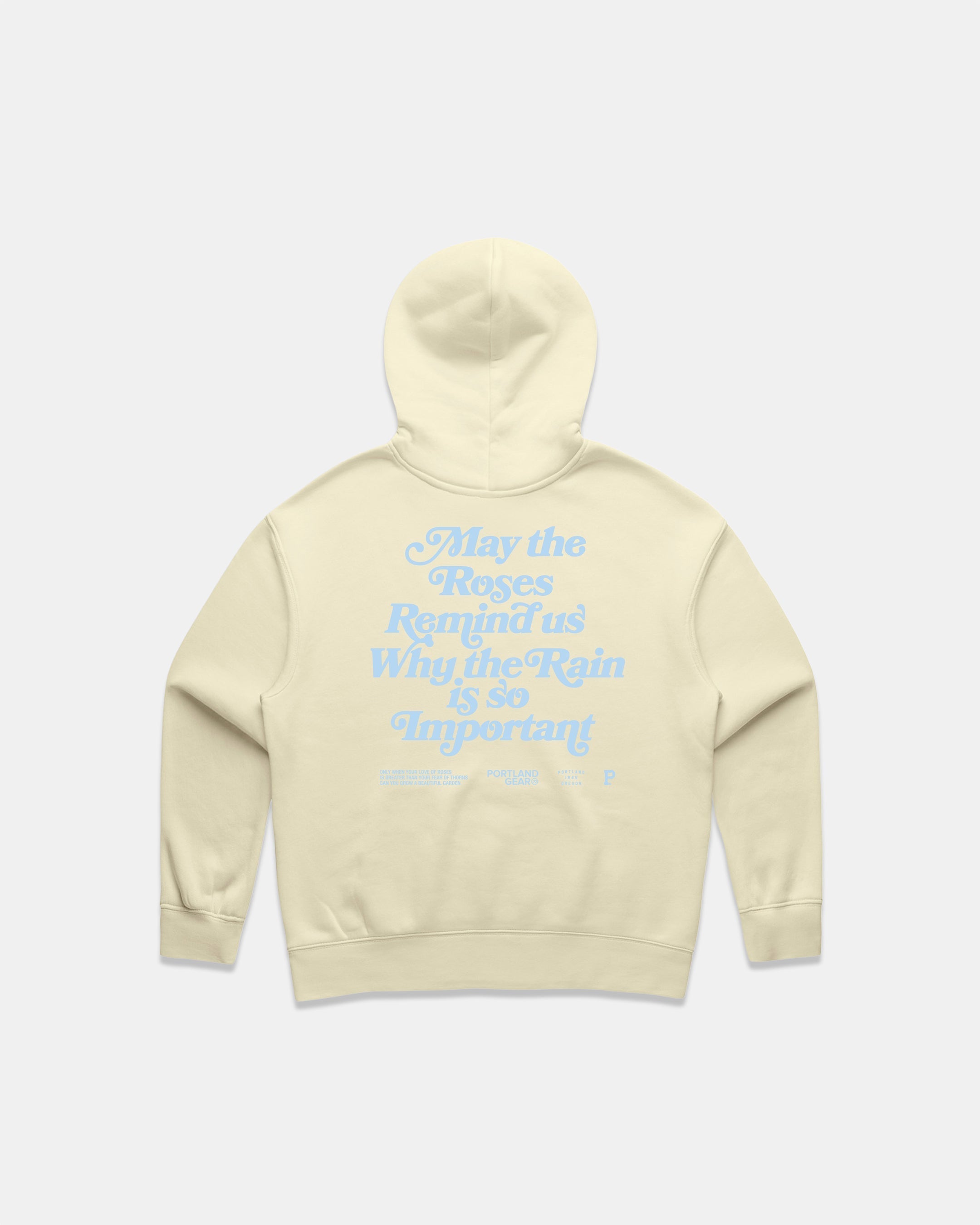 Back view of a Butter colored hoodie with a light blue puff screen print slogan about roses and rain.