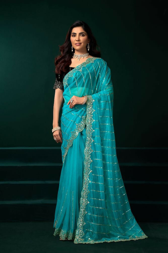 Turquoise blue net party wear saree with a contrasting black velvet blouse