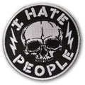 Close up of a circular black and white patch featuring a skull, lightning bolts, and the text I Hate People.