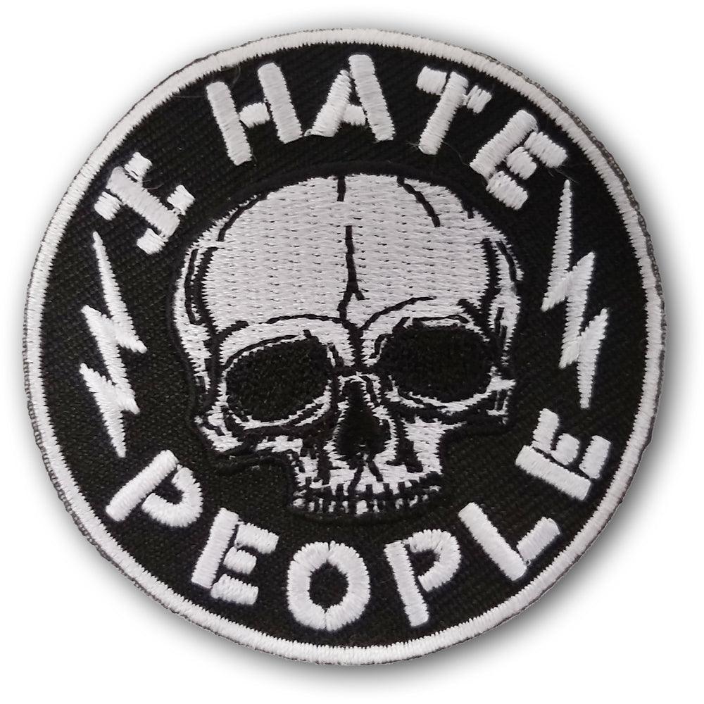Close up of a circular black and white patch featuring a skull, lightning bolts, and the text I Hate People.