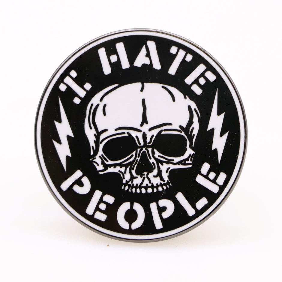 Close up of the I Hate People Enamel Pin on a dark background, ideal for bags or apparel.