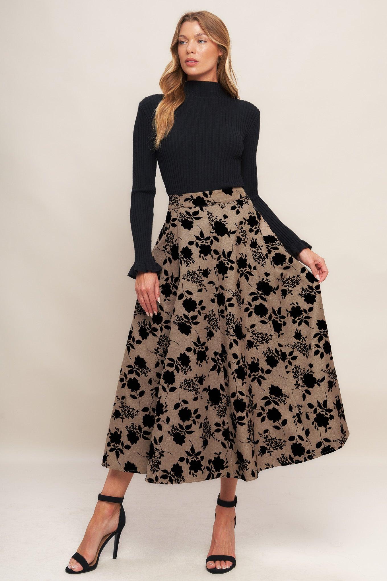 Model wearing a taupe midi circle skirt with black floral flocking detail