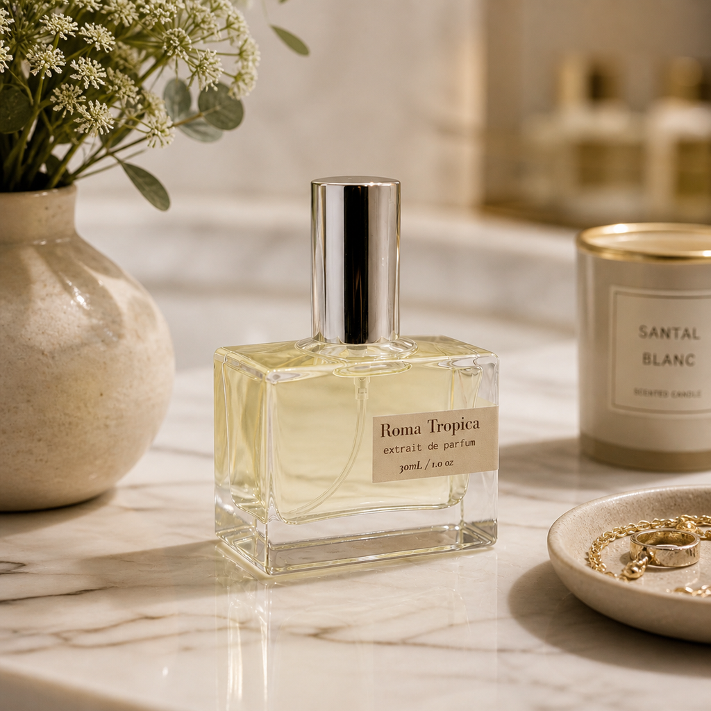 Clear glass bottle of Roma Tropica Extrait de Parfum with a pale yellow liquid.