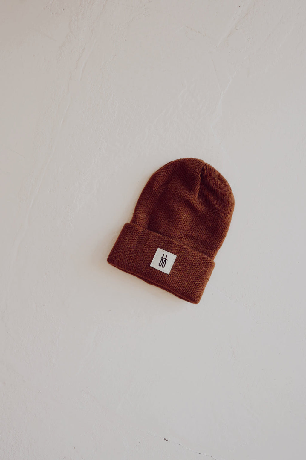 Chestnut colored ribbed knit beanie displayed in a minimalist streetwear style