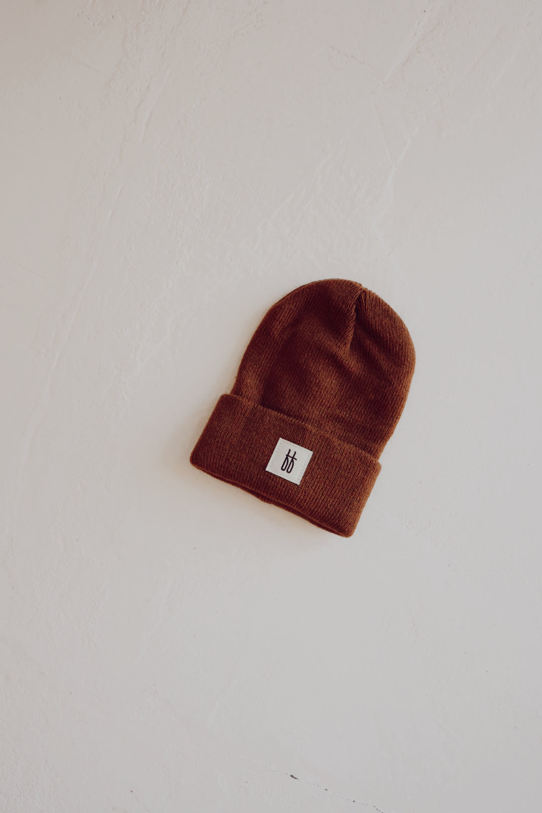 Chestnut colored ribbed knit beanie displayed in a minimalist streetwear style