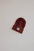 Chestnut colored ribbed knit beanie displayed in a minimalist streetwear style
