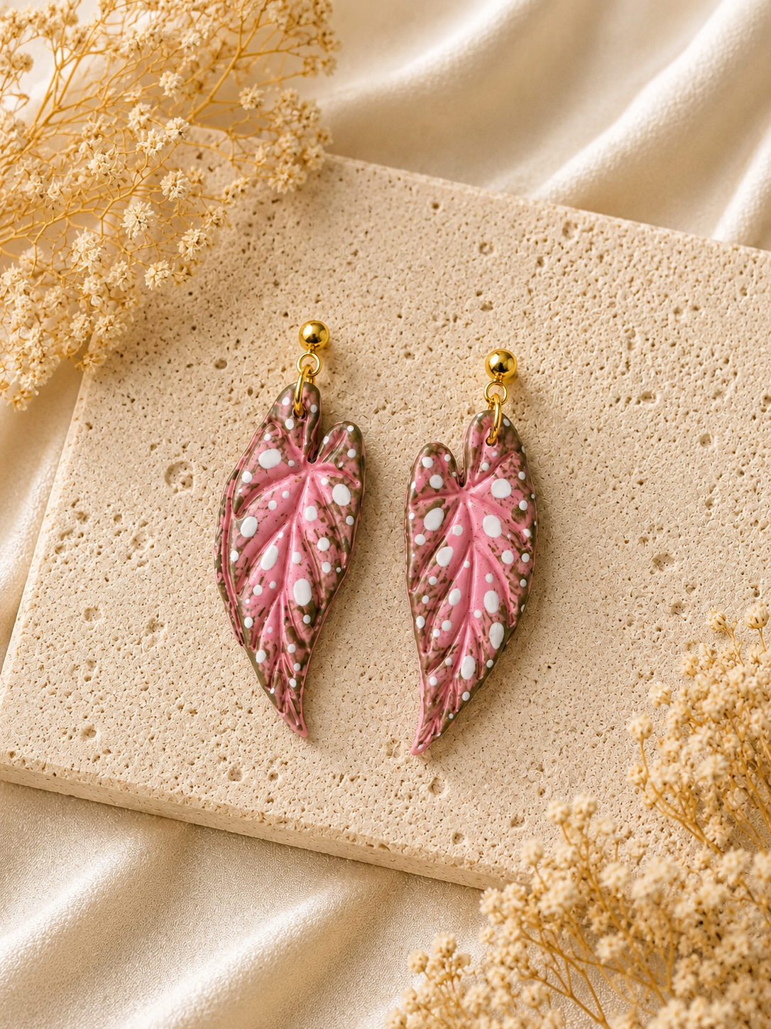 Detailed pink Begonia Maculata leaf earrings with hand-painted accents