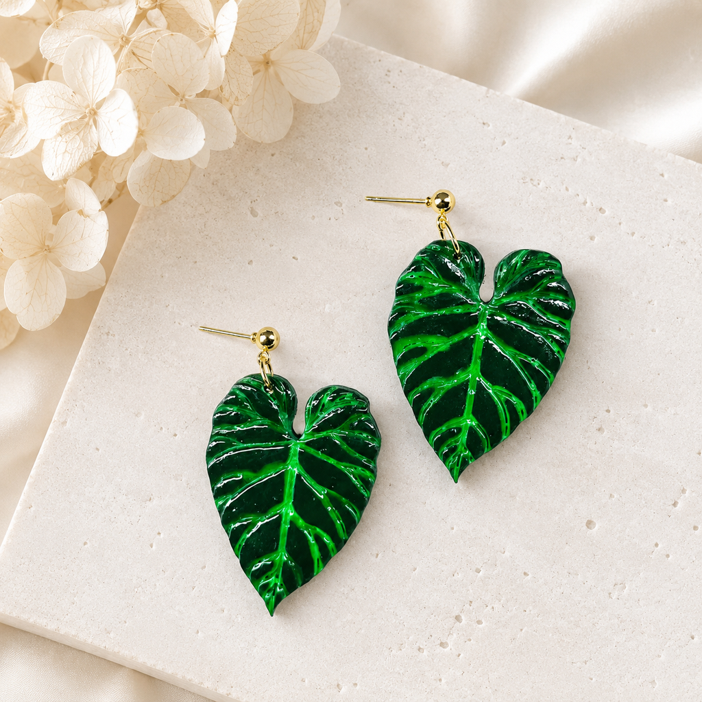 Handmade Philodendron Verrucosum earrings with green and gold details and glow-in-the-dark veins.