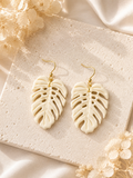 Cream and gold Ghost Monstera leaf earrings in a minimalist bohemian style.