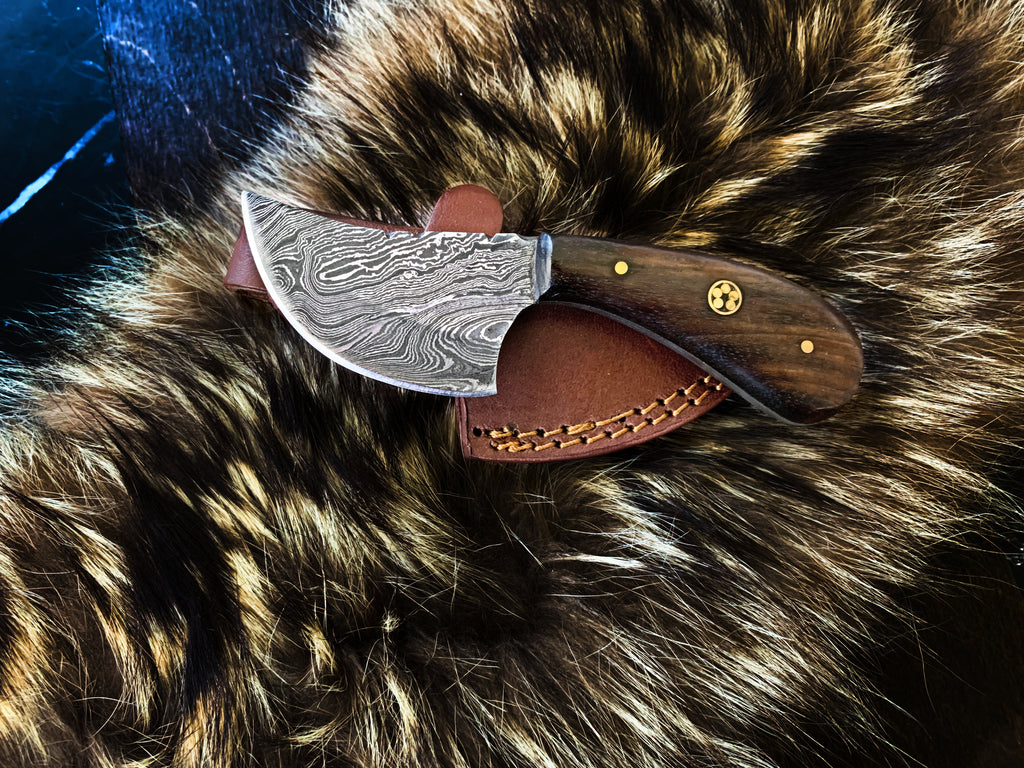 A traditional Damascus steel utility knife with a walnut wood handle and silver blade