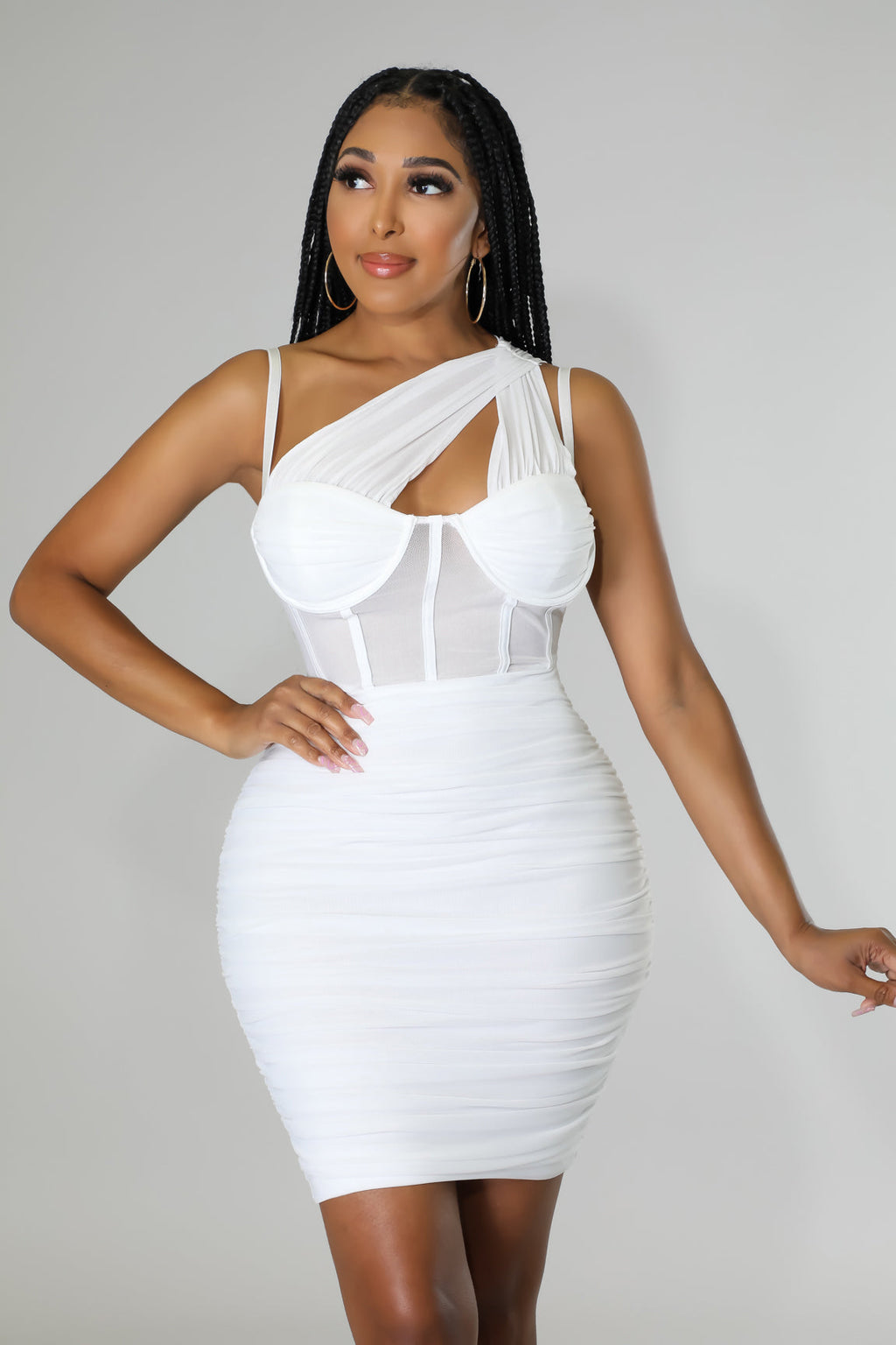 Model wearing a white one-shoulder ruched mini dress with a sheer corset bodice and underwire detailing.