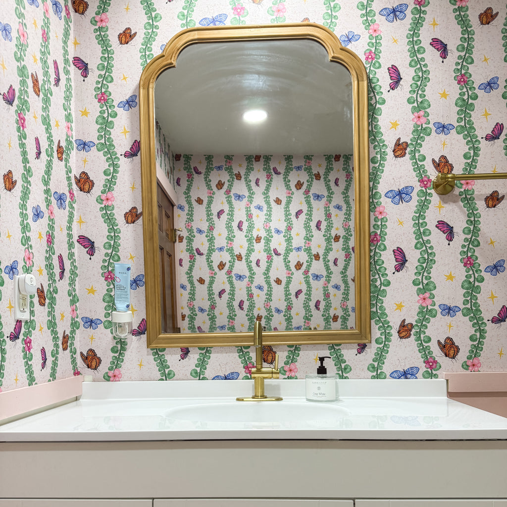 Whimsical bohemian Sylva wallpaper featuring pink and green abstract print on a neutral background.