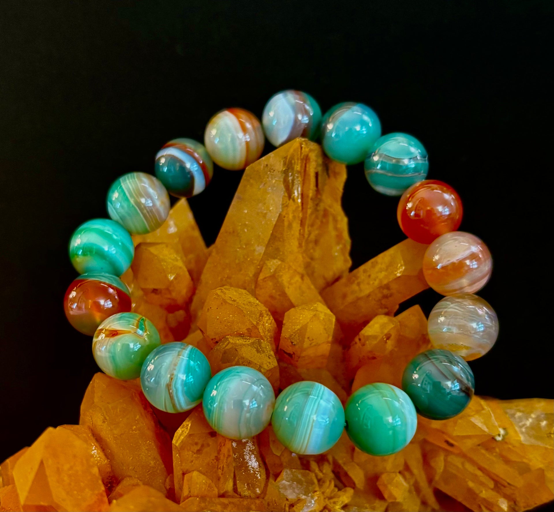 Close up of a multi-colored earth tone Enchanted Forest Agate beaded bracelet on a wrist