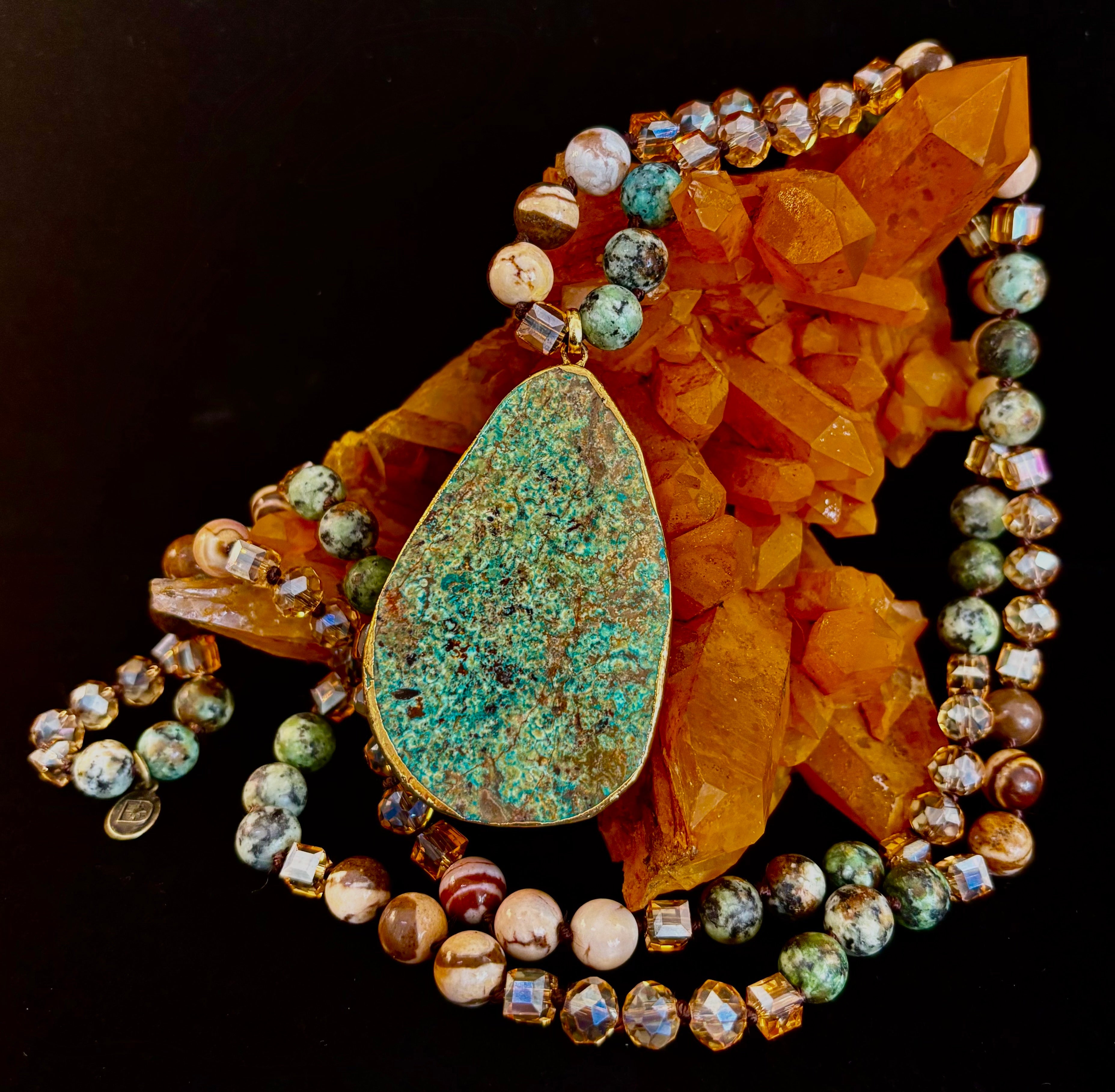 Close up of a Desert Oasis Jade teardrop pendant necklace with gold-plated bezel and bohemian beaded chain
