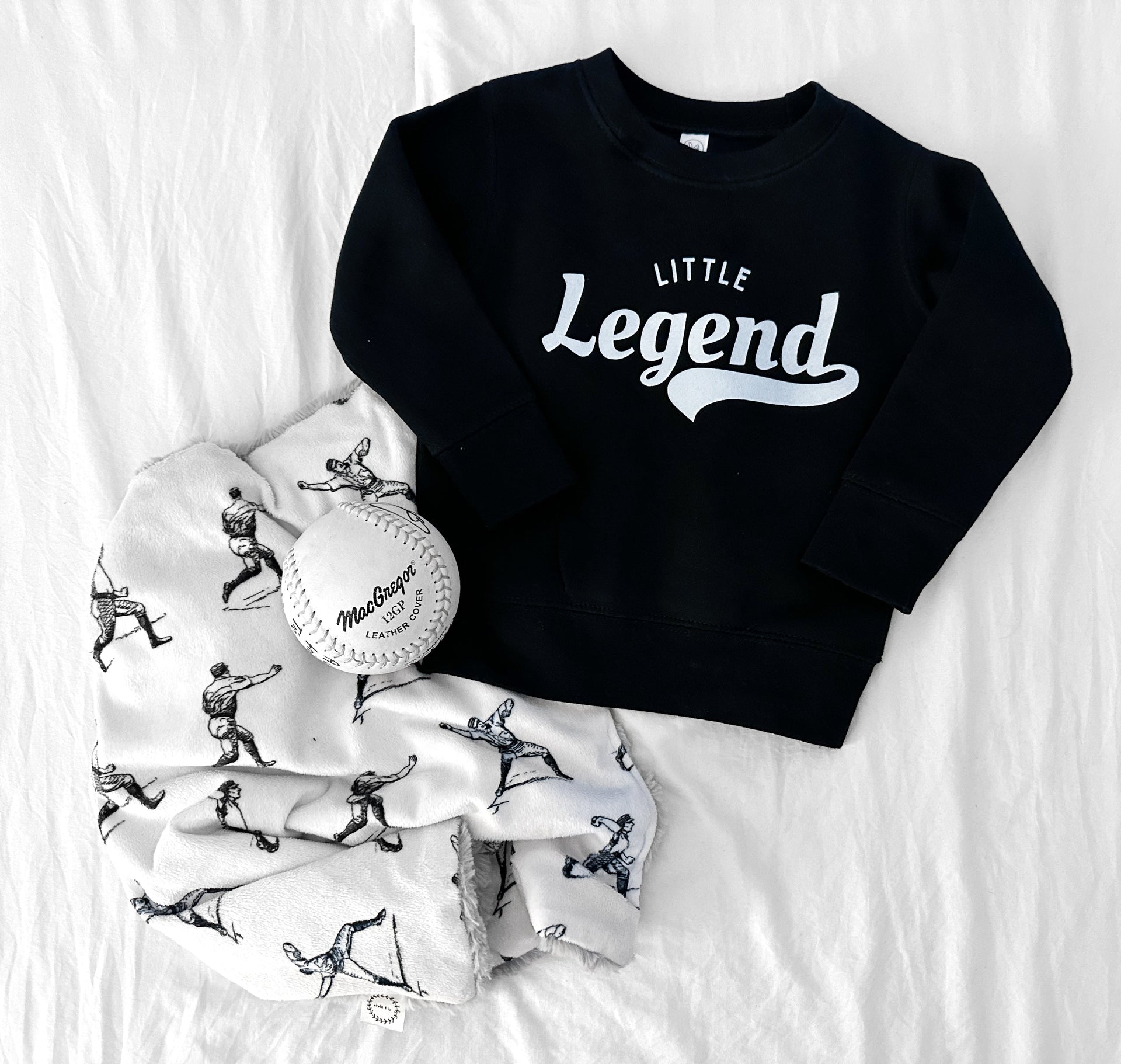 Child wearing a minimalist black Little Legend knit pullover sweatshirt.