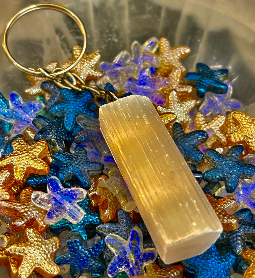 Minimalist selenite crystal keychain with silver hardware on a neutral background