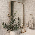 Vera Wallpaper featuring cream botanical floral motifs on a soft sage green background.