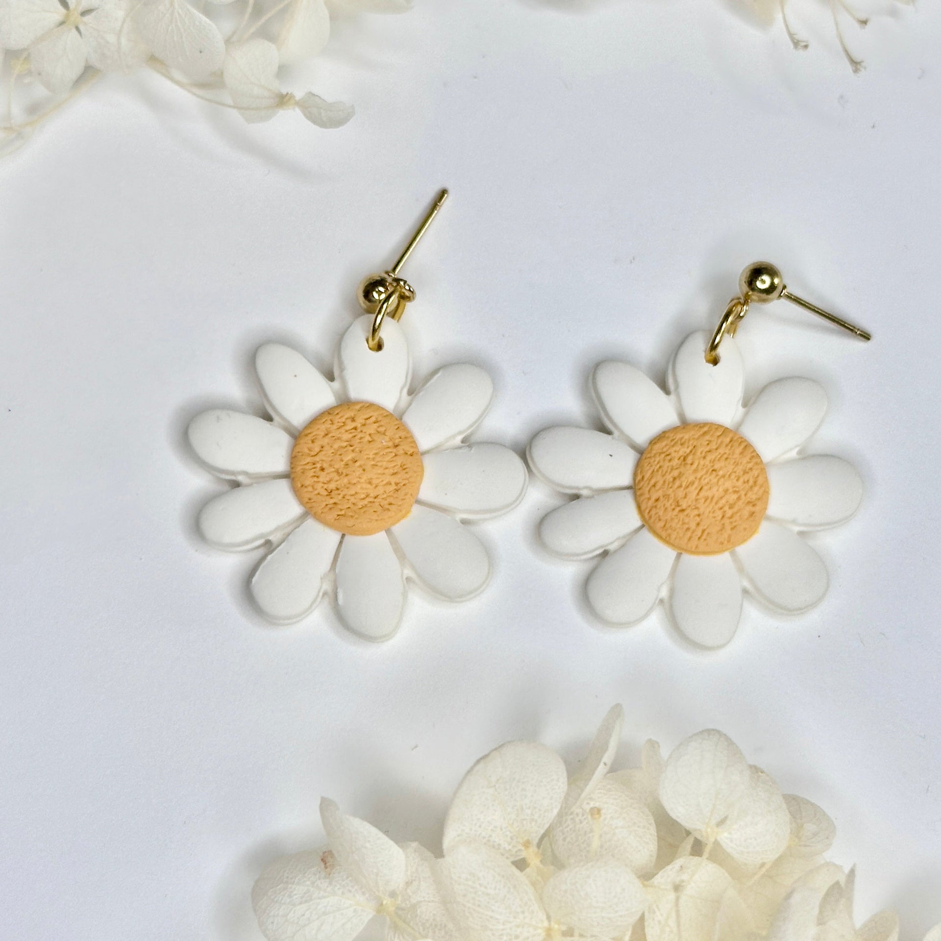 Close-up of golden Retro Daisy Drop earrings featuring a 70s flower aesthetic