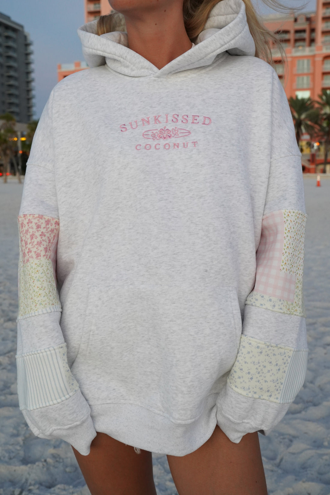 Model wearing a quilted pastel embroidered hoodie with a relaxed unisex fit