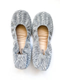 A pair of Zealous Zebra patterned women's flats on a white background