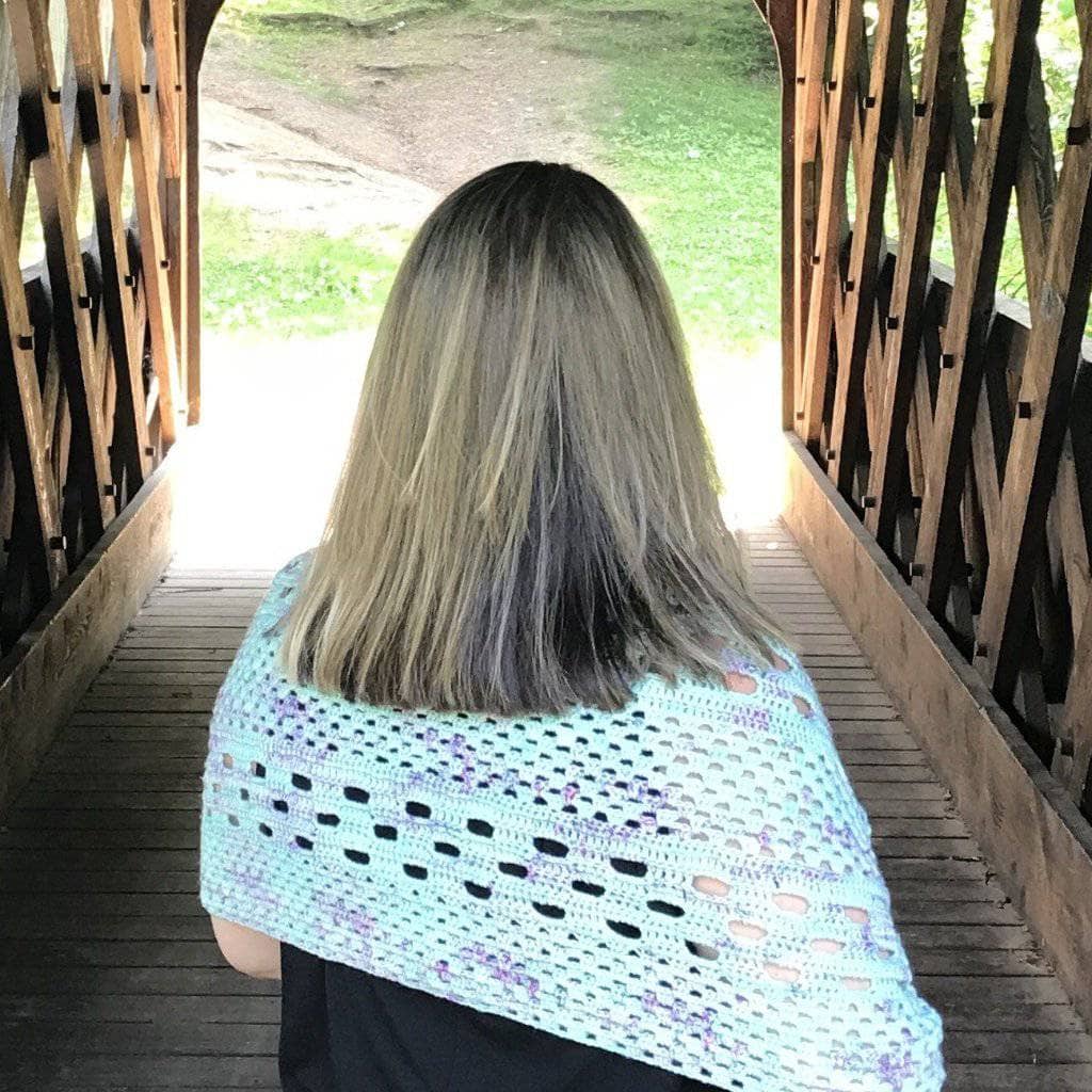A finished solid-stitched crochet shawl made from soft merino wool yarn.