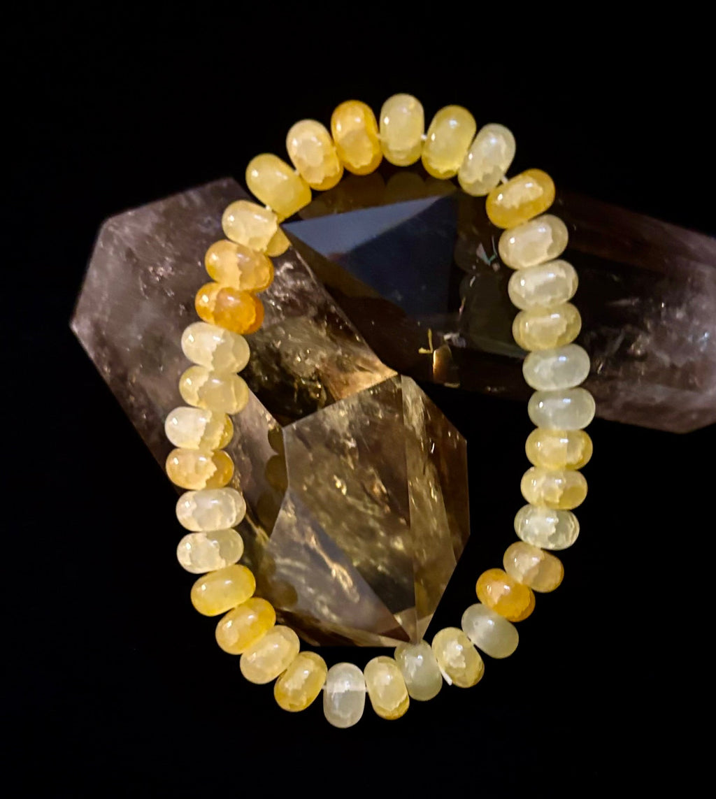 Yellow Agate Rondelle bead bracelet resting on dark crystal formations