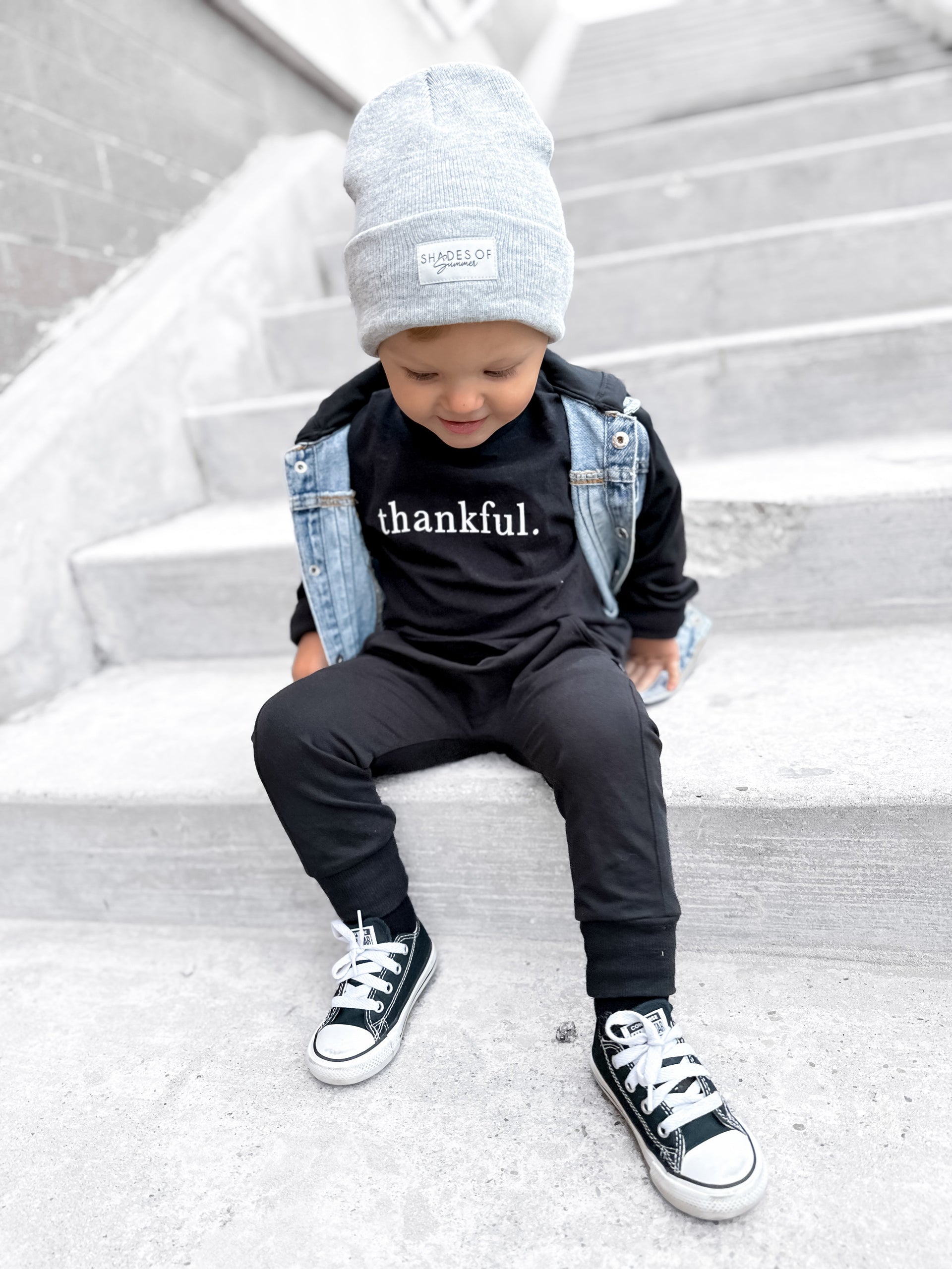 Minimalist toddler graphic tee in black with the word thankful printed in white.