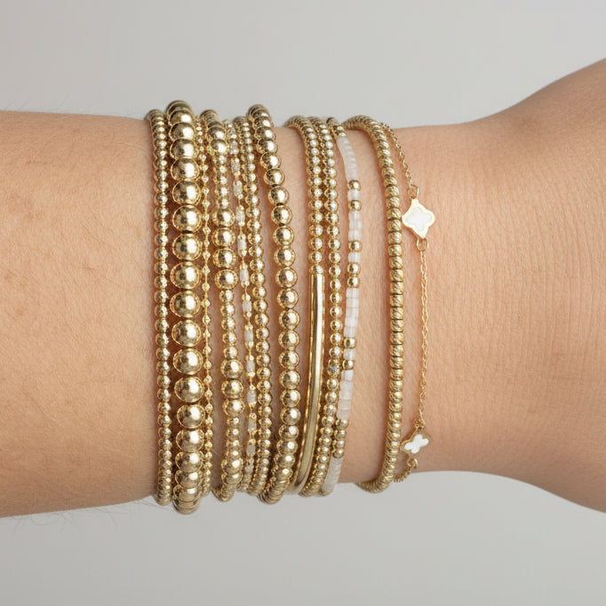 Set of 8 Miss Bold 14K gold-filled bead bracelets worn as a stack for a modern bohemian aesthetic