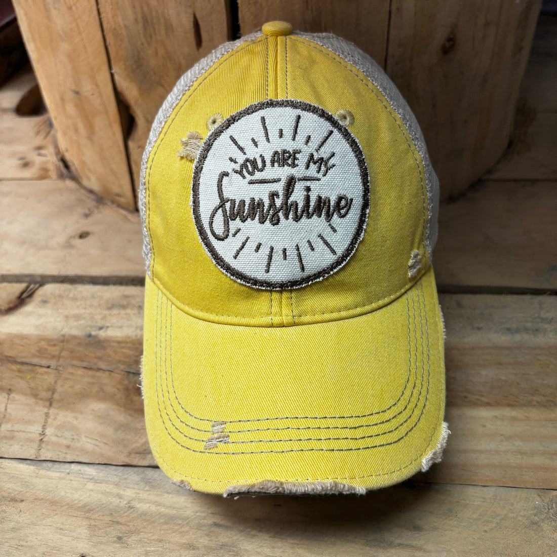 Yellow distressed baseball cap with You Are My Sunshine embroidered patch and tan mesh back.
