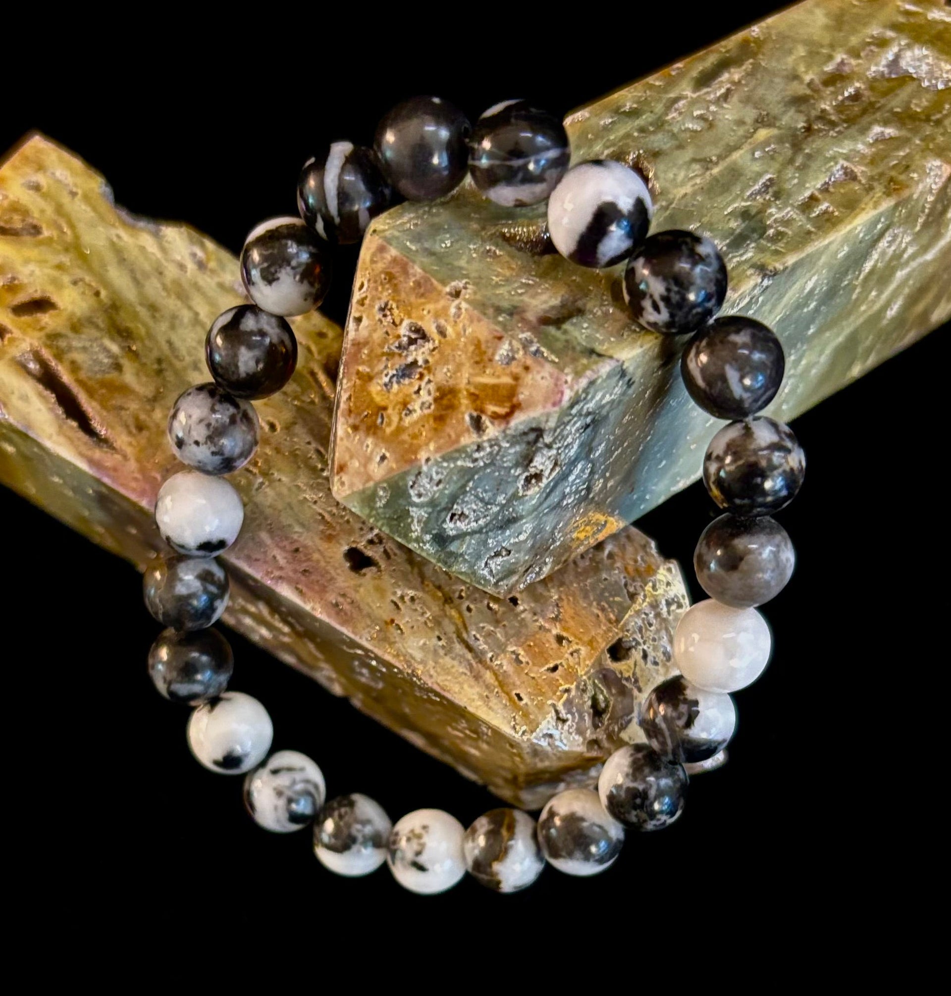 Zebra stone beaded stretch bracelet with black and white patterns on dark background