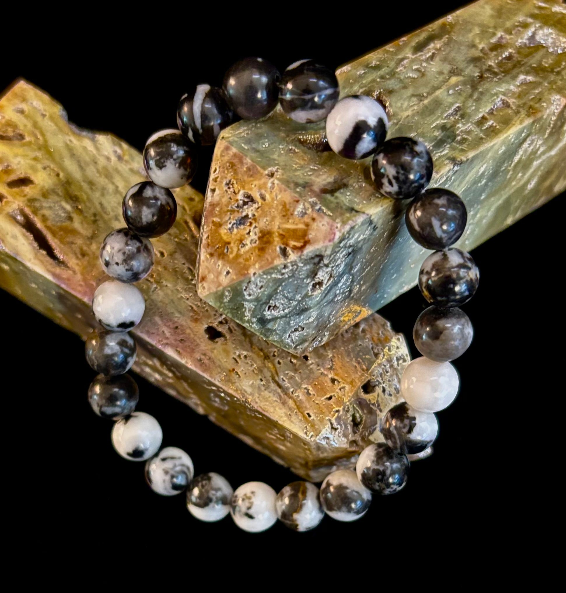 Zebra stone beaded stretch bracelet with black and white patterns on dark background