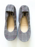 A pair of women's ballet flats with a classic plaid pattern and pink detail accents, shown from top-down and bottom-up views.