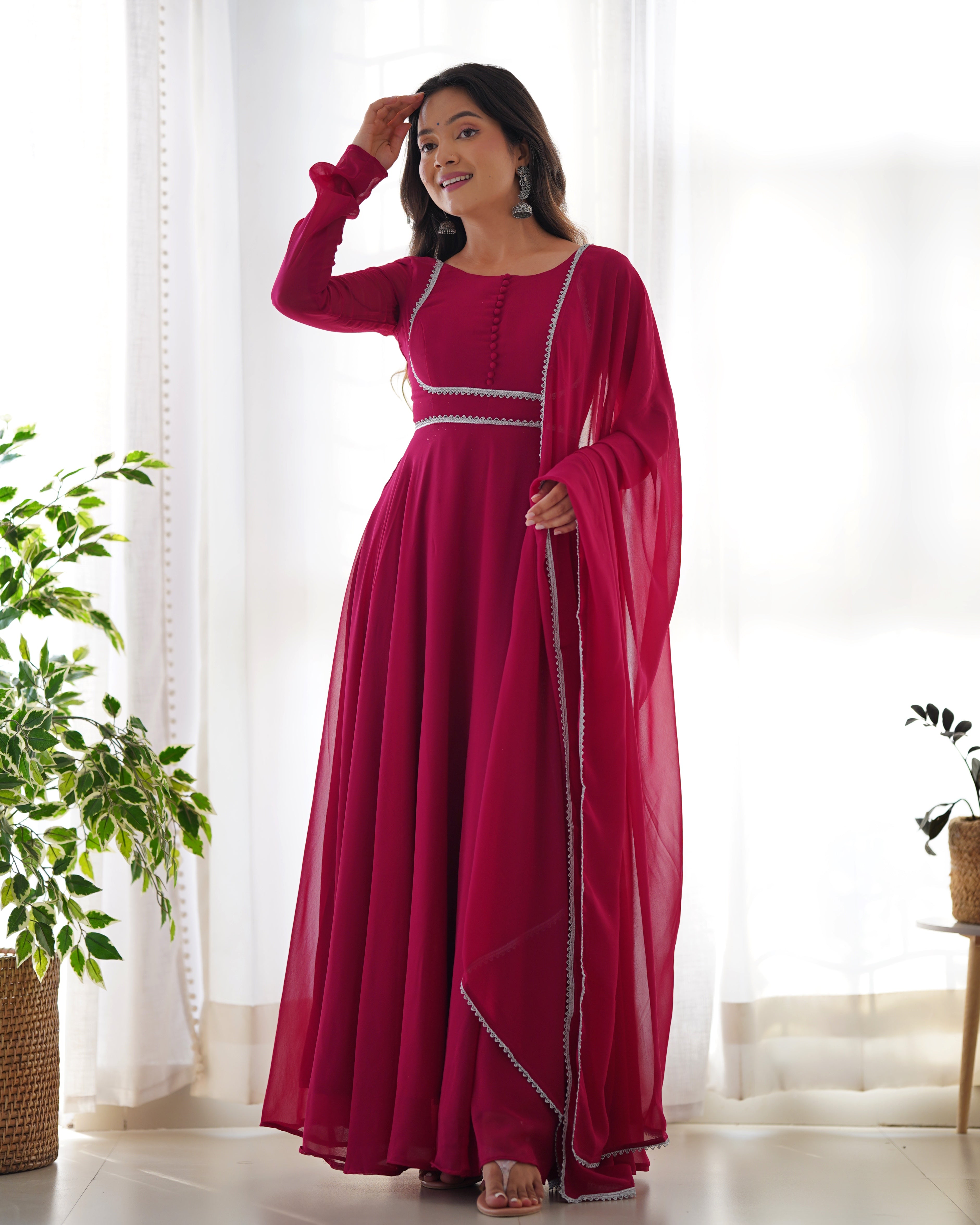 A front view of a vibrant pink Anarkali gown with a designer yoke, potli buttons, and matching pants.