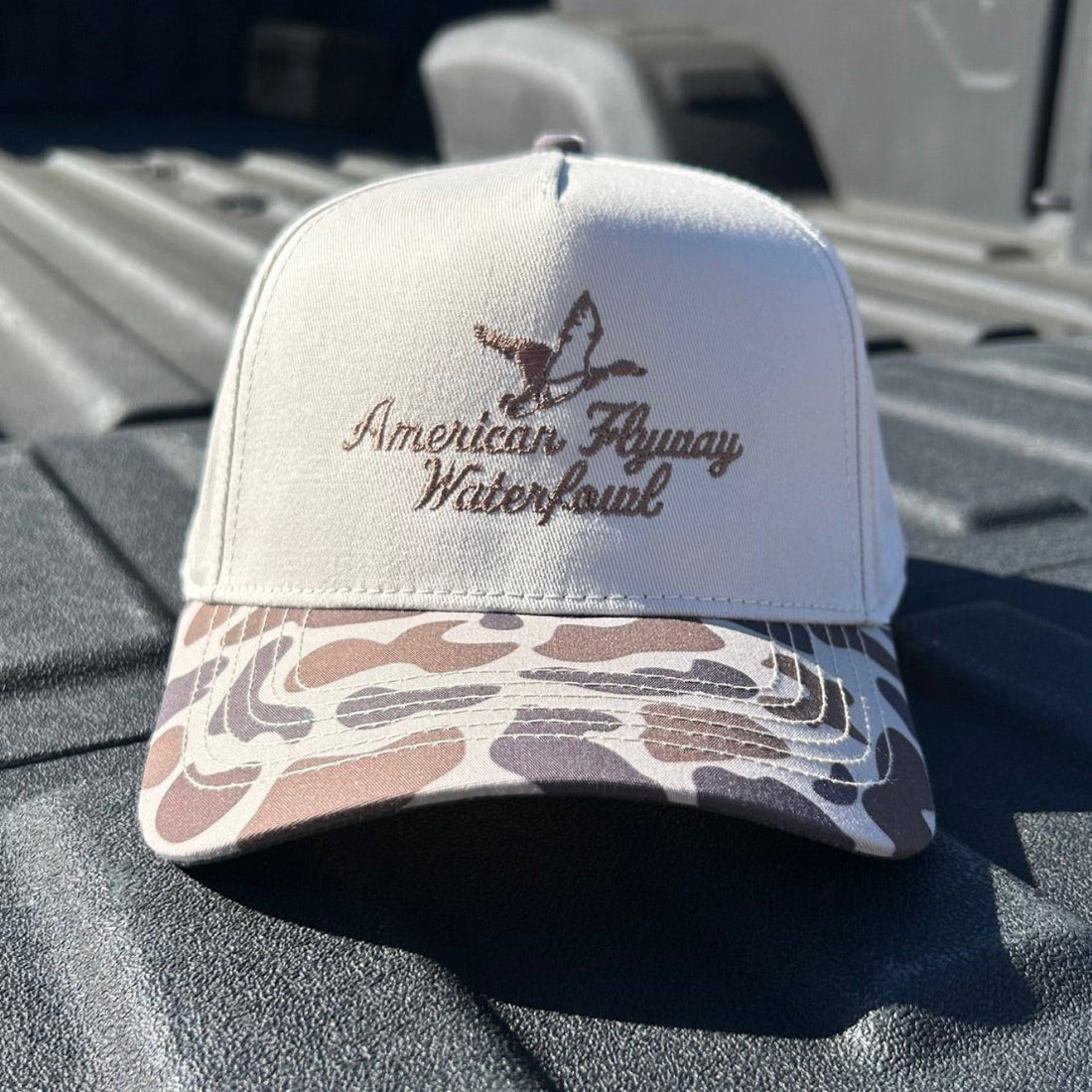 Brown trucker hat with OSC patterned brim and snapback closure