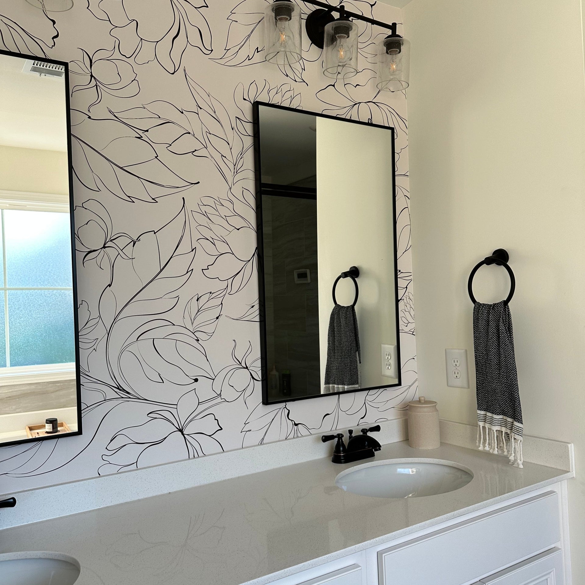 Modern black and white floral Elizabeth wallpaper on a minimalist living room wall