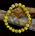 Yellow Turquoise gemstone beaded bracelet resting on a crystal specimen