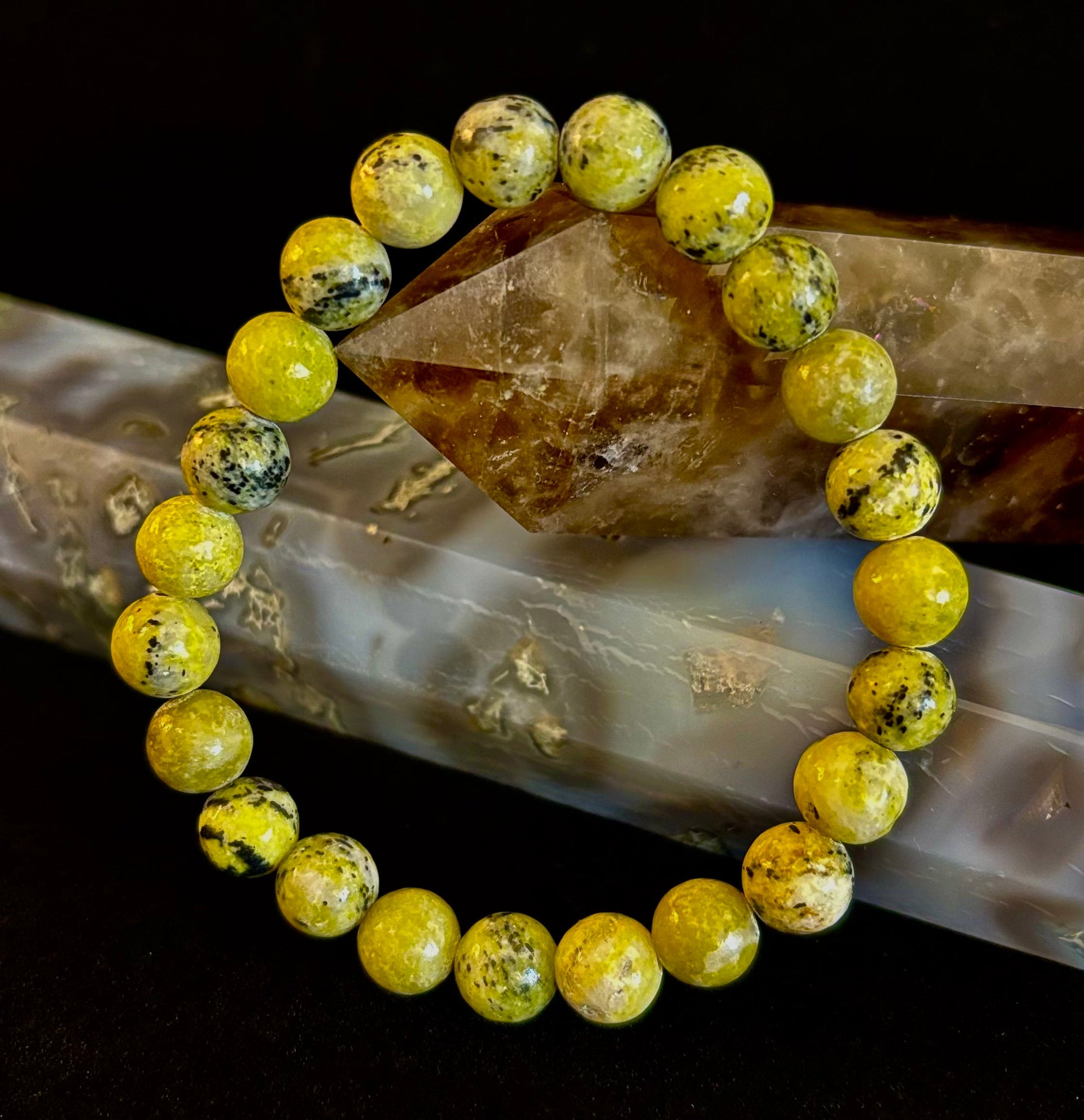 Yellow Turquoise gemstone beaded bracelet resting on a crystal specimen