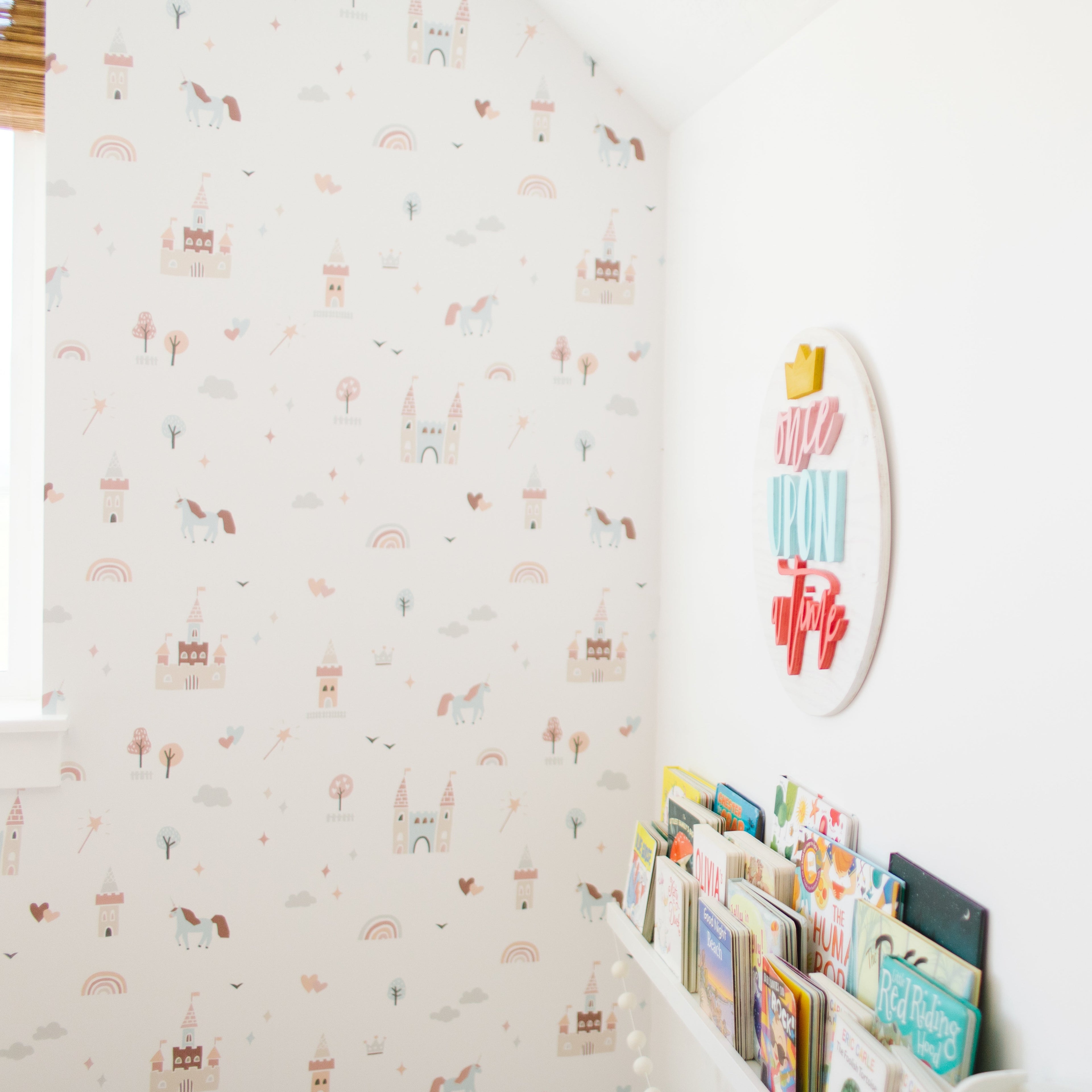 Ella whimsical nursery wallpaper in pastel pink, light blue, and soft orange.