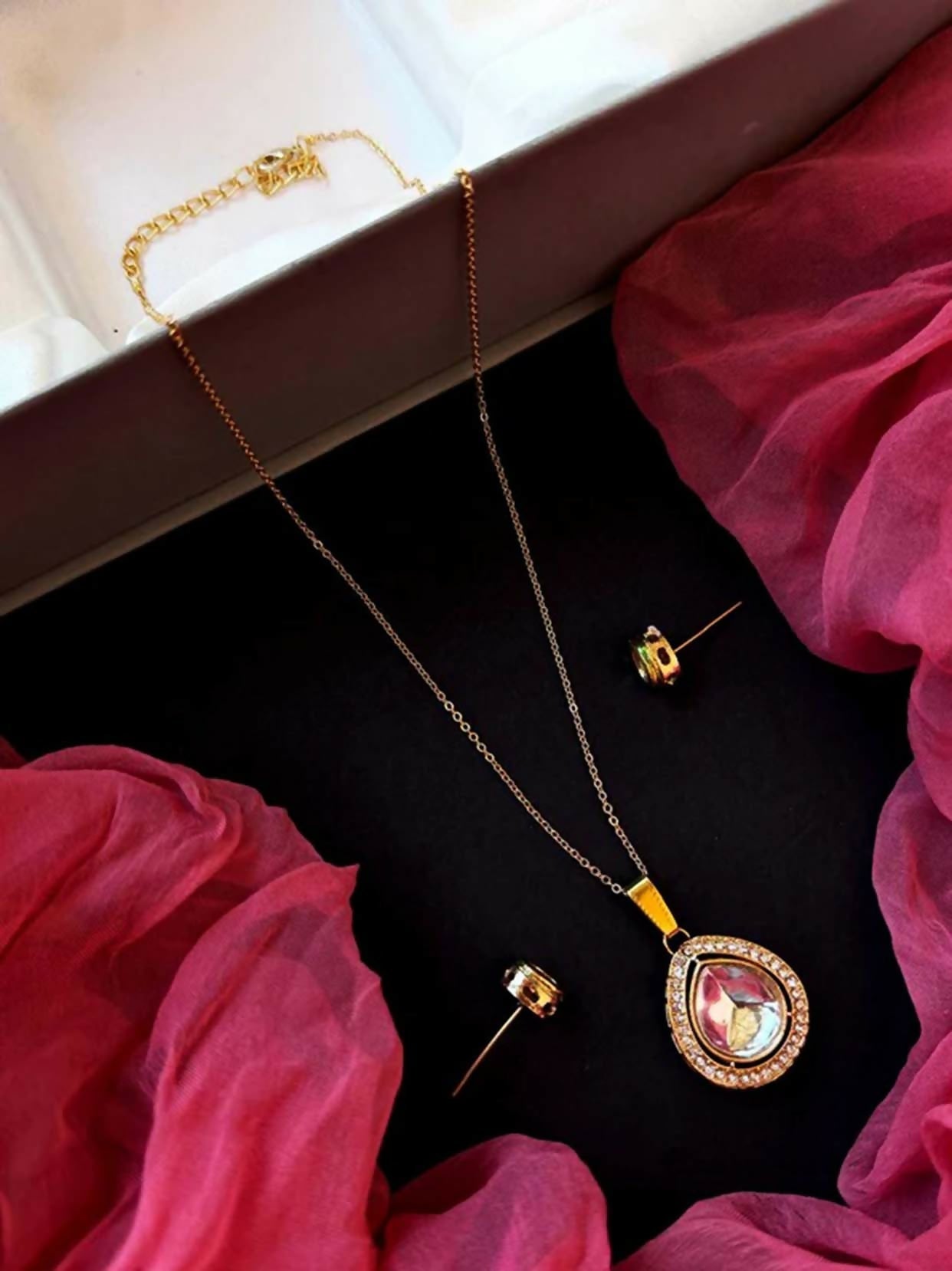Gold Kundan pendant necklace and matching earring set with intricate traditional detailing