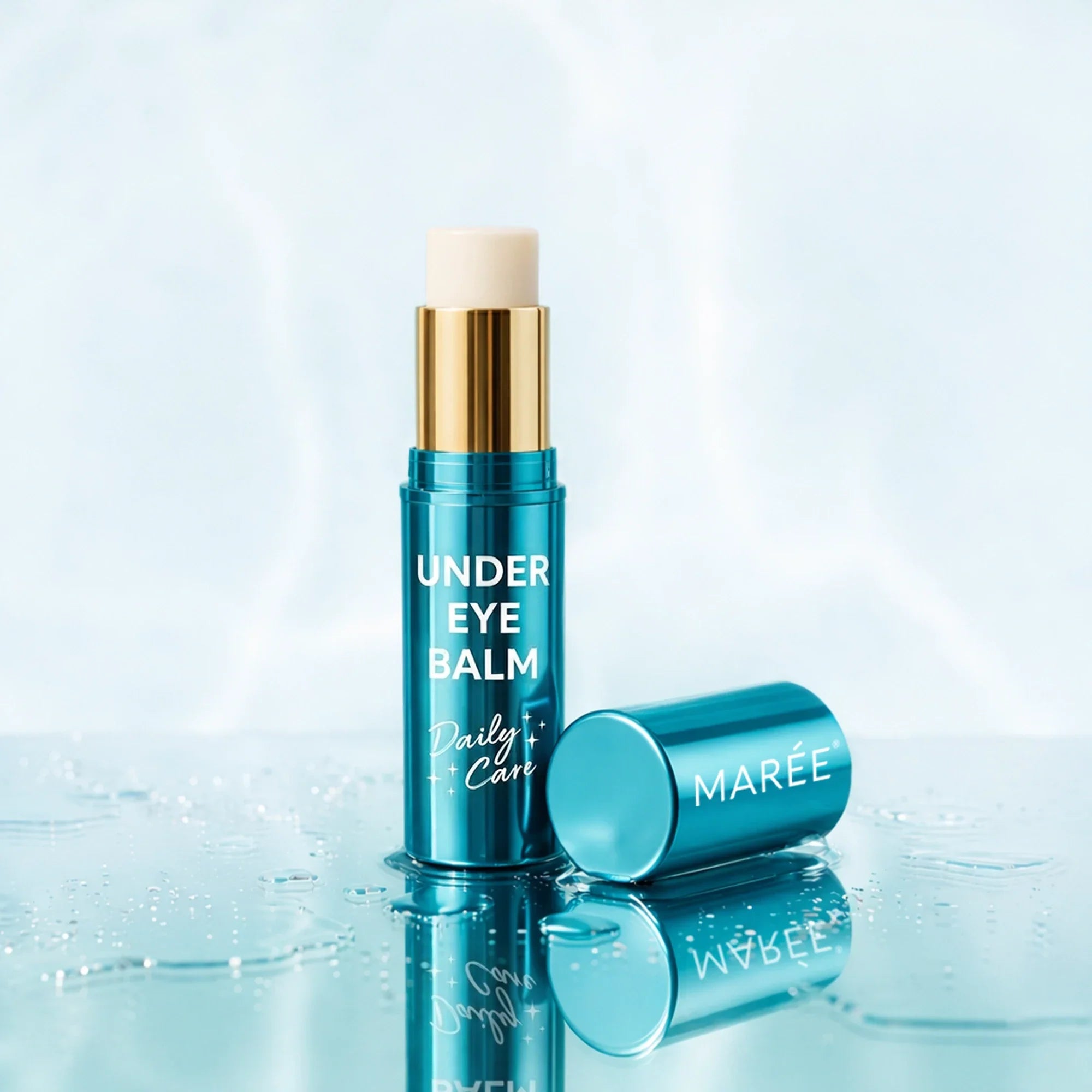 Maree under eye balm stick in a metallic blue tube on a reflective surface