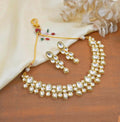 Close-up of a luxurious crème-colored Kundan jewellery set featuring traditional copper craftsmanship.
