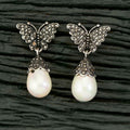 A pair of modern silver-tone brass earrings featuring black AD stones.