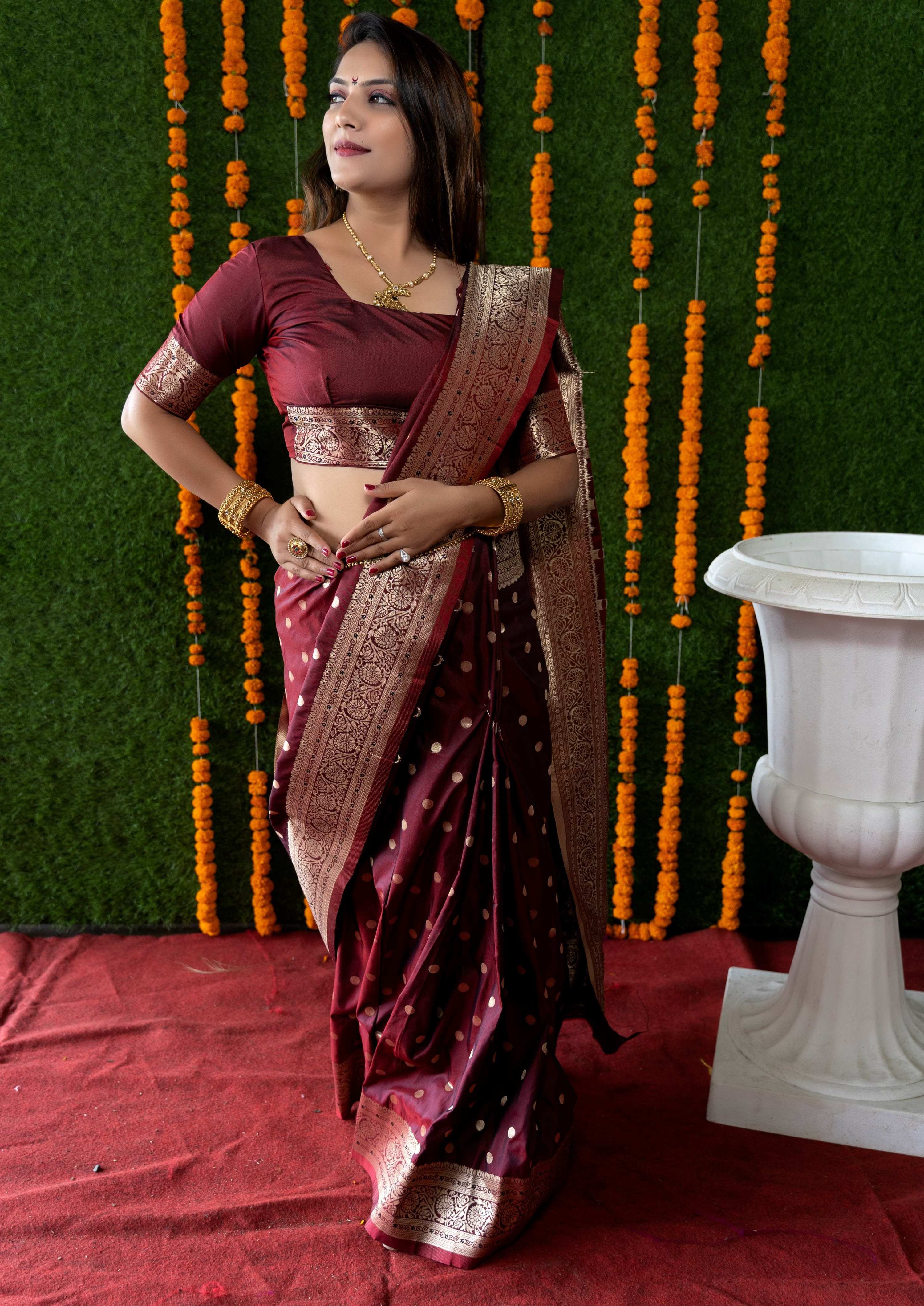 Maroon Banarasi silk saree featuring traditional Zari woven motifs and matching half-sleeve blouse.