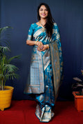 Teal-colored handloom Banarasi silk saree with Zari woven patterns and matching half-sleeve blouse.
