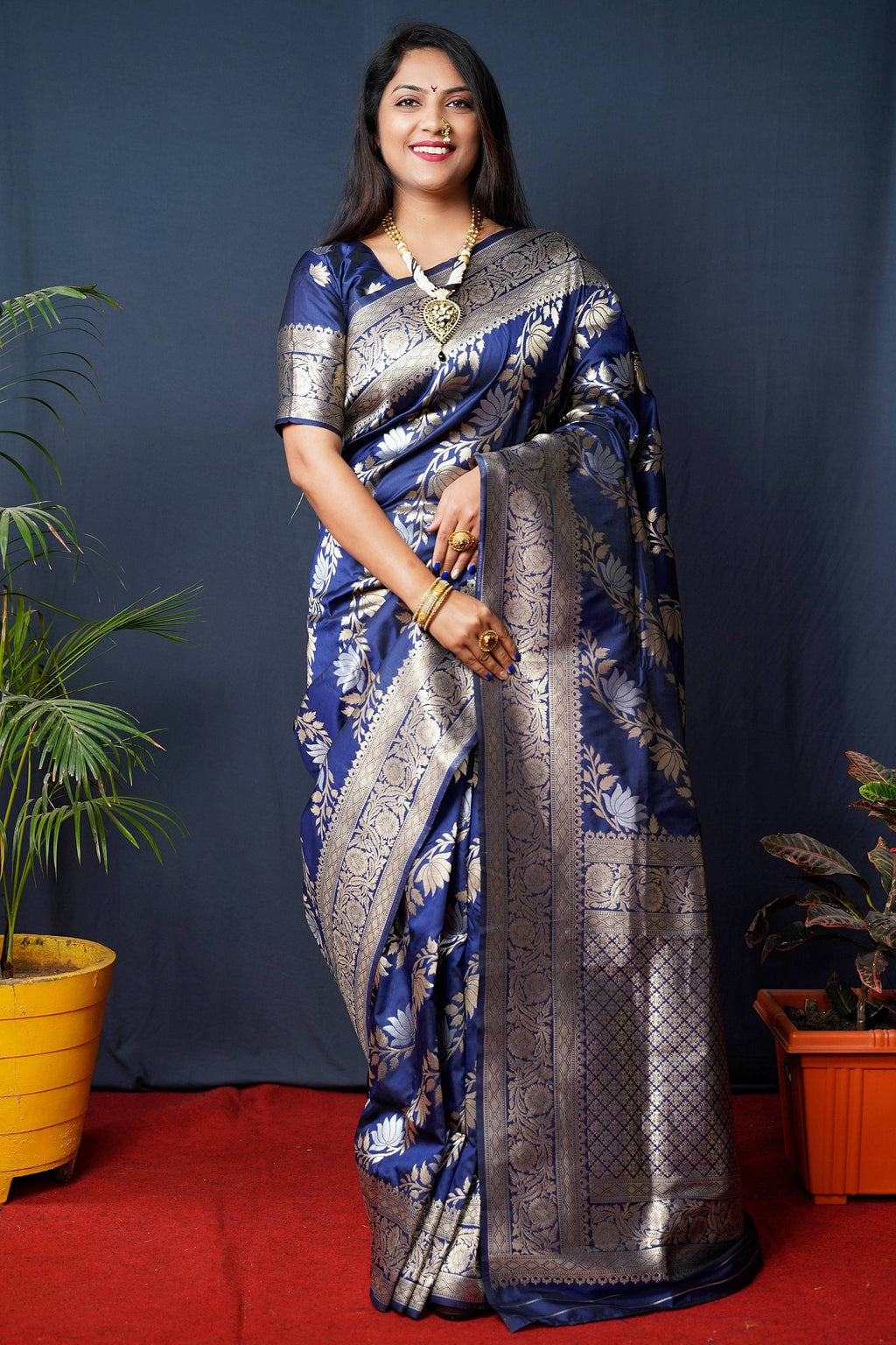 Navy blue Banarasi silk saree with intricate gold Zari woven borders and matching half-sleeve blouse.