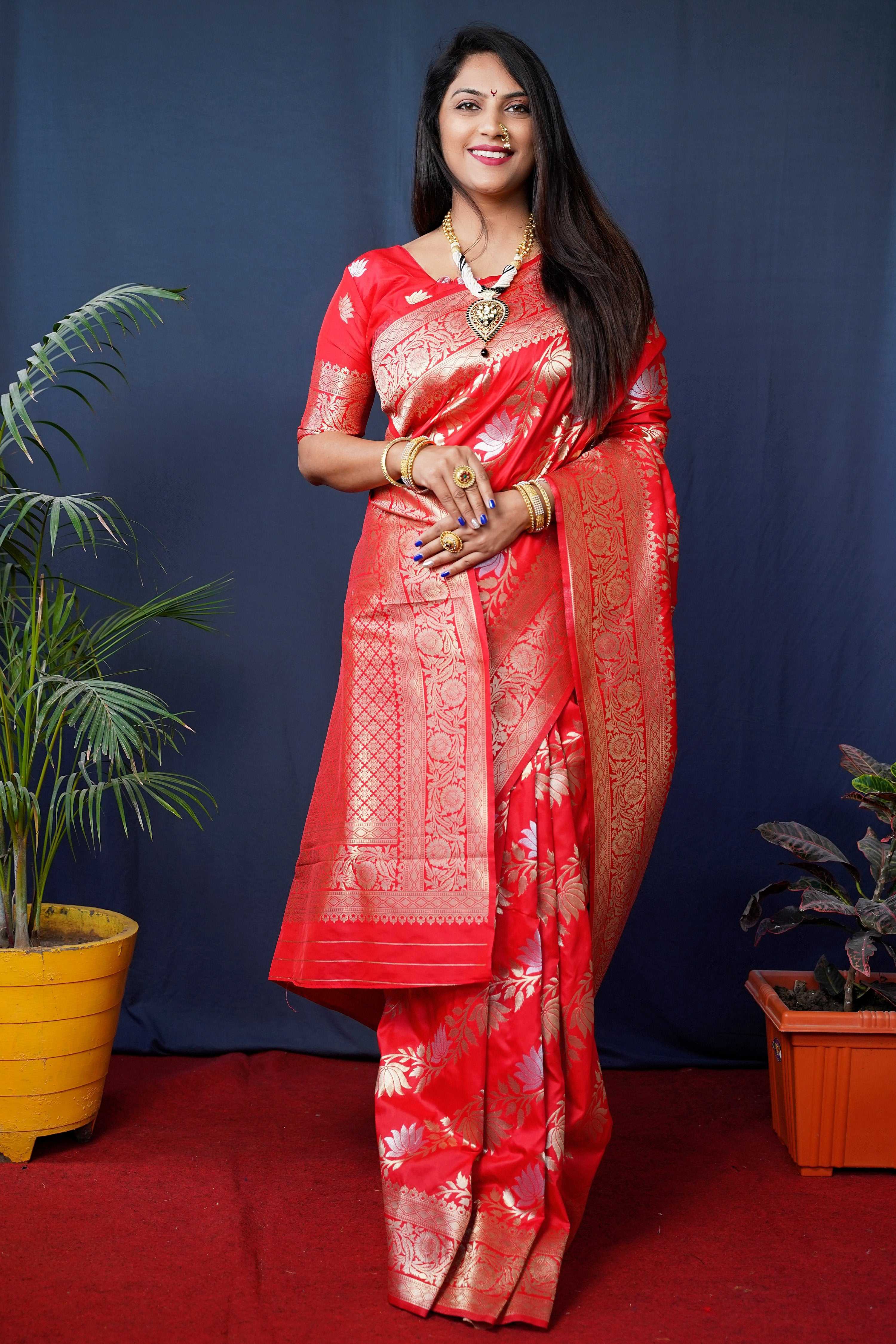 A beautiful red handloom Banarasi silk saree with intricate zari woven patterns and a matching blouse piece.
