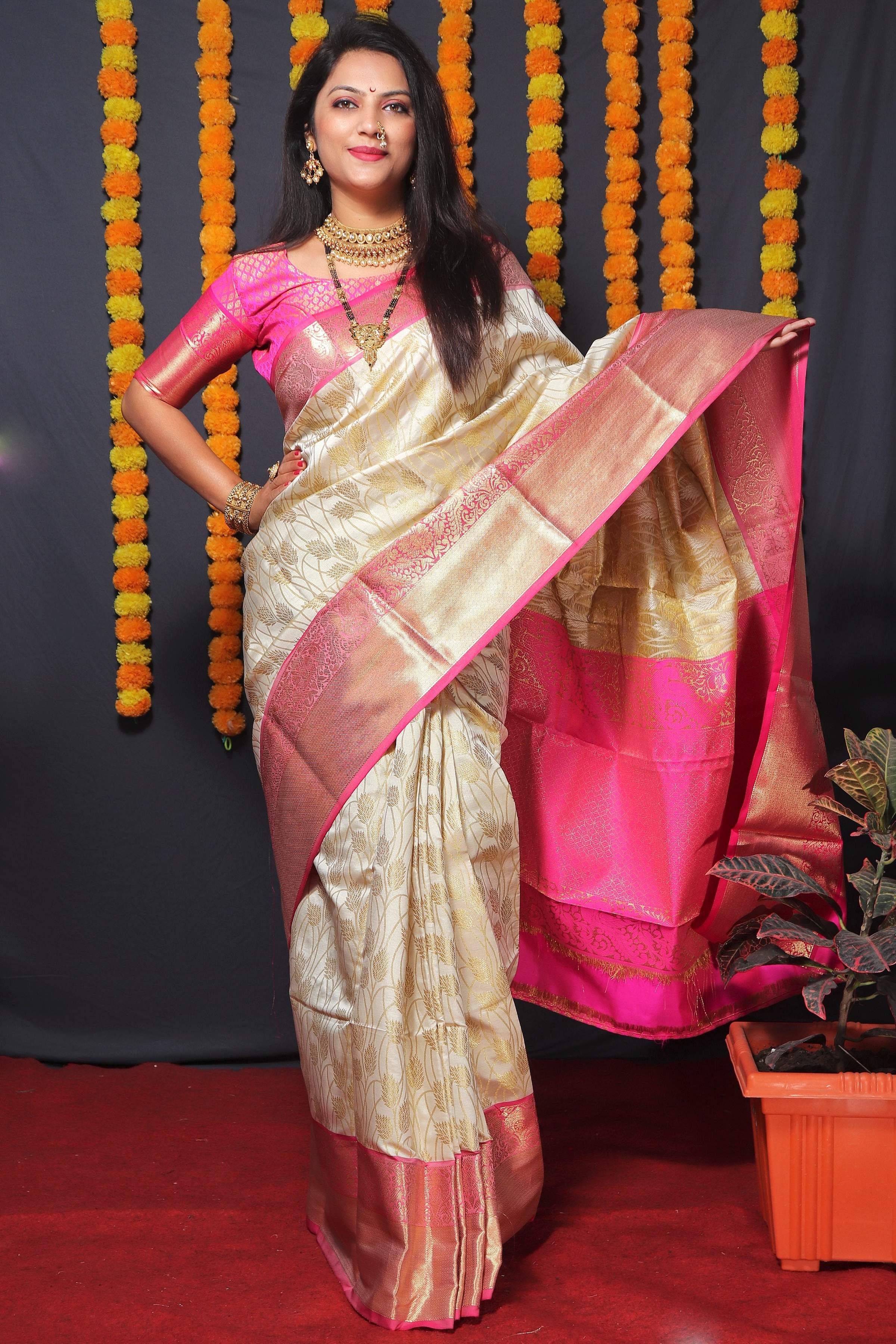 Off-white Kanchipuram silk saree with intricate gold Zari borders and matching blouse.