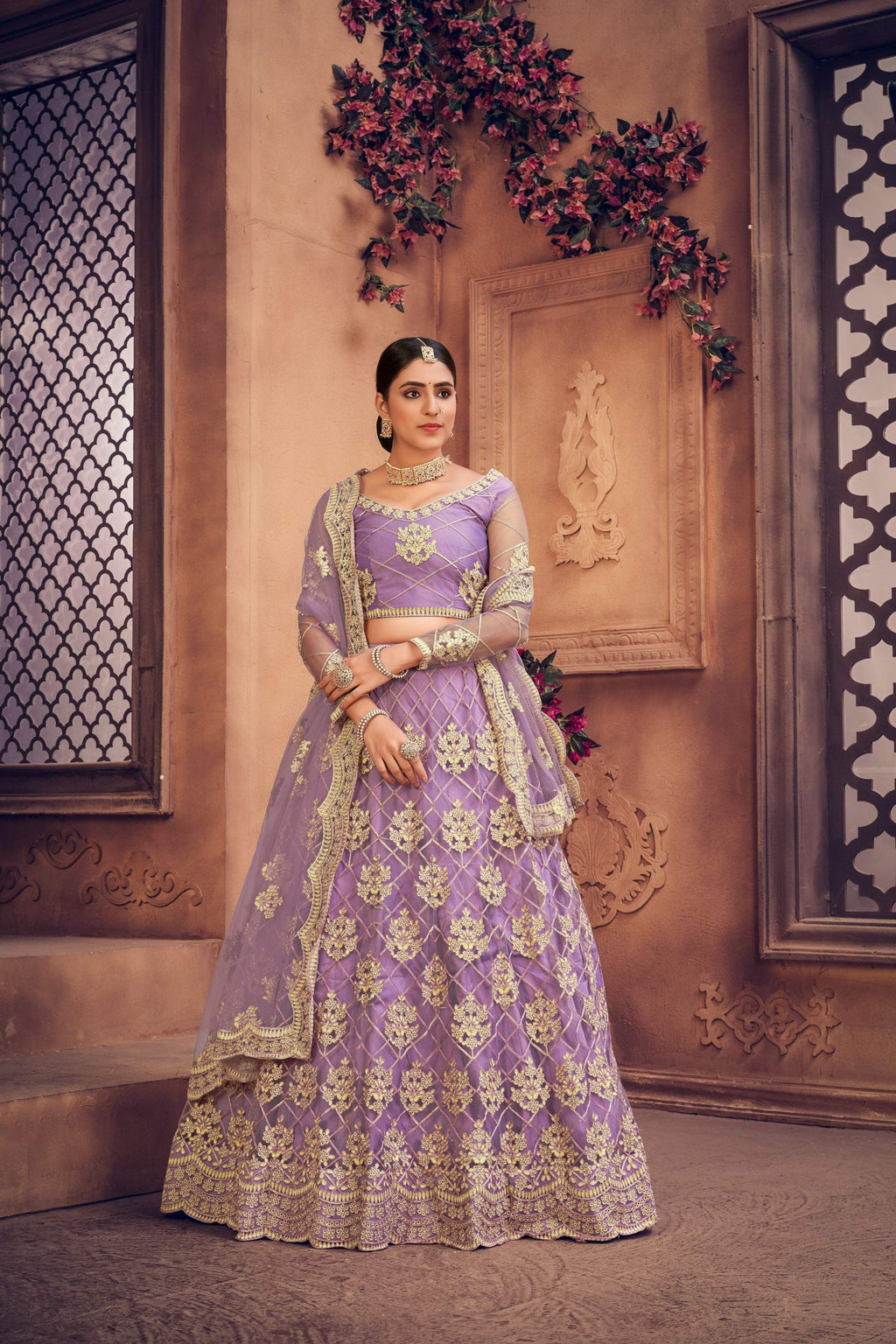Purple net lehenga choli with detailed thread embroidery and elegant design.