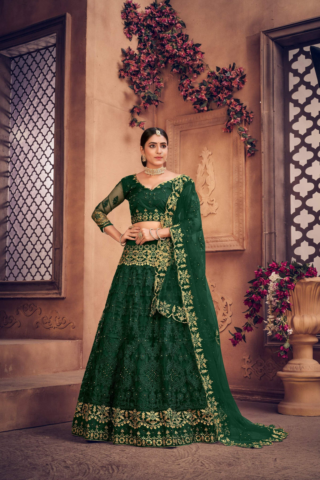 Dark green net lehenga choli featuring fine thread embroidery for festive occasions.
